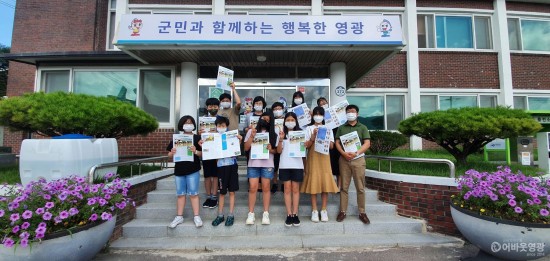 6.지난 16일, 묘량앙초등학교 학생기자단이 학생들이 제작하는 묘량면 최초의 마을 신문에 묘량면장의 축하인사가 담긴 창간호를 전달하며 면사무소 앞에서 기념사진을 찍었다 .jpg